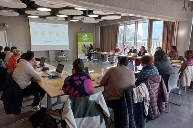 Salle de réunion avec une vingtaine de participants munis d'ordinateurs face à un écran de projection et une bannière Projet Alimentaire Territorial.