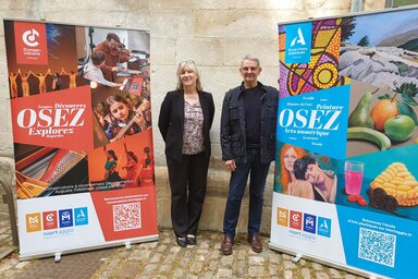 Le Vice président en charge de la culture, et une F. Beguin posent devant les kakémonos du Conservatoire Auguste-Tolbecque et de l'École d'arts plastiques