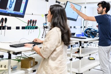Deux étudiants travaillent sur ordinateurs et équipements techniques dans un atelier pédagogique de l'ENSAM Niort.
